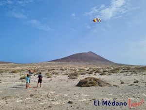 Familia volando una cometa en Reserva Natural Especial de Montaña Roja, El Médano, Tenerife Sur